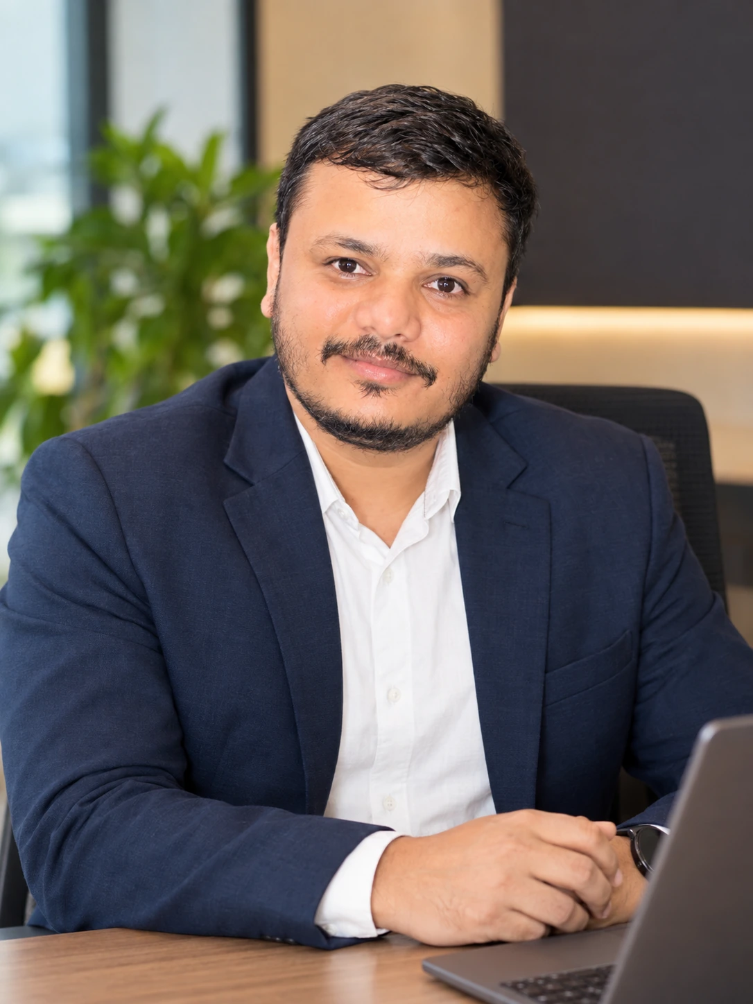 Anurag Kumar Verma at his desk in a navy blazer